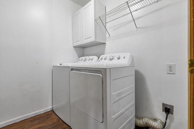 laundry area featuring separate washer and dryer, cabinet space, dark wood-style floors, and baseboards