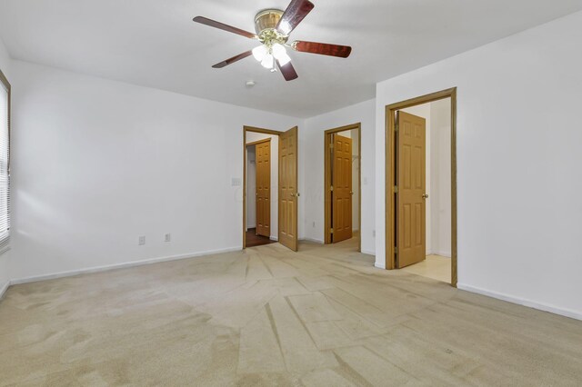 unfurnished bedroom with ceiling fan, light colored carpet, and baseboards