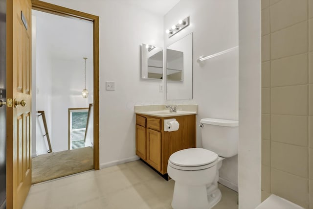 bathroom featuring toilet, vanity, and baseboards