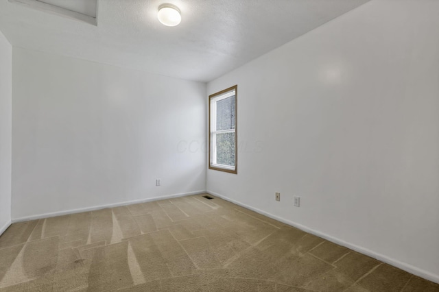 carpeted spare room featuring baseboards