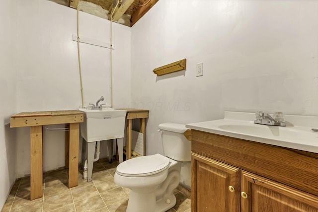 bathroom featuring toilet, tile patterned flooring, and a sink