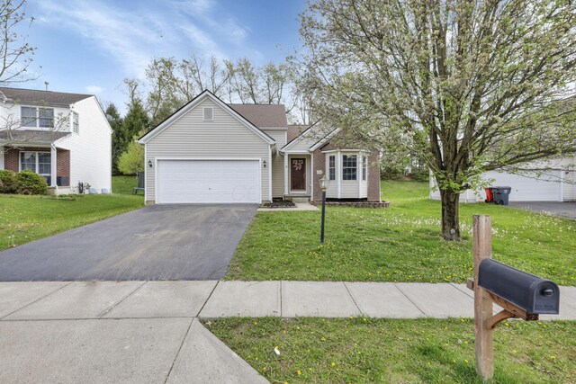 ranch-style home with a front yard, an attached garage, and aphalt driveway