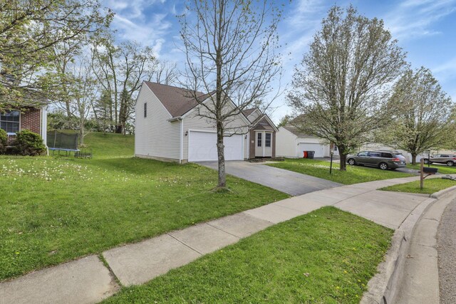 view of front facade with a garage, a trampoline, a front lawn, and driveway