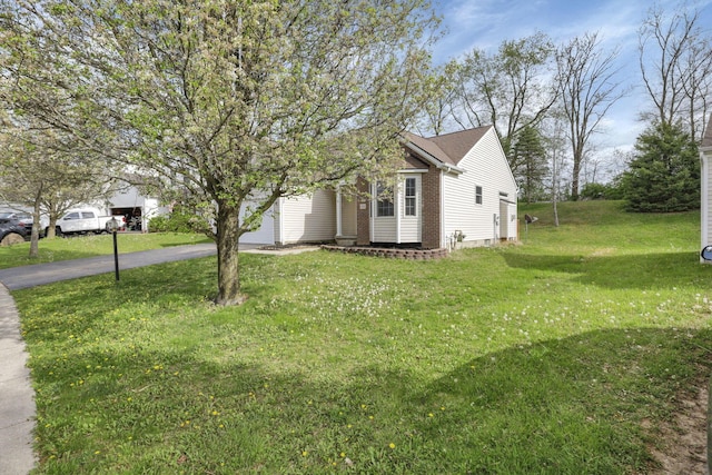 view of front of property featuring aphalt driveway and a front lawn