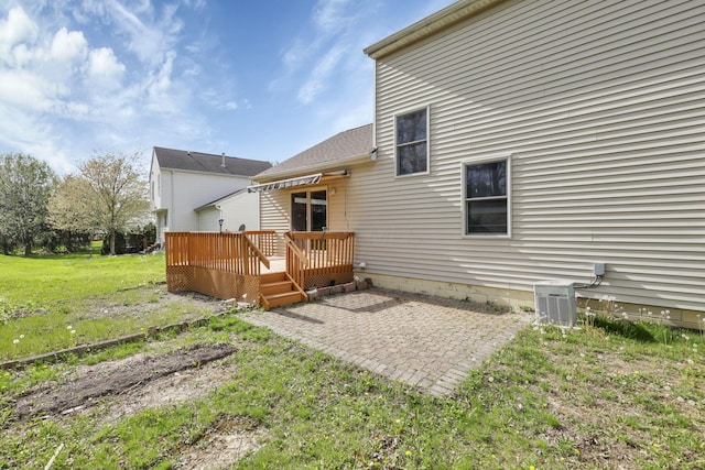 back of property with cooling unit, a lawn, a wooden deck, and a patio area