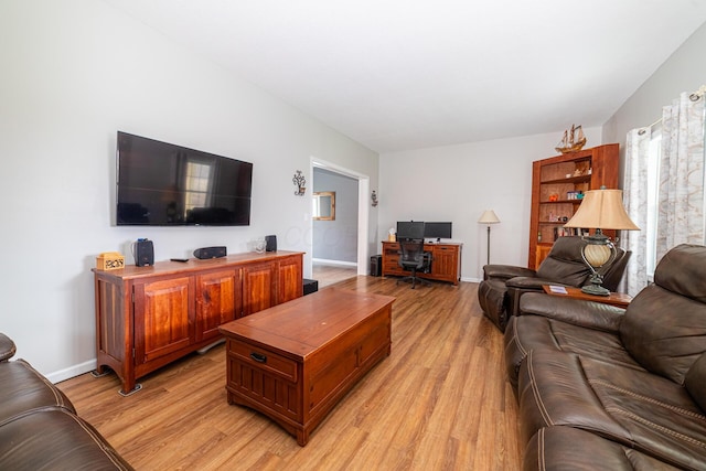 living area featuring light wood-style floors and baseboards