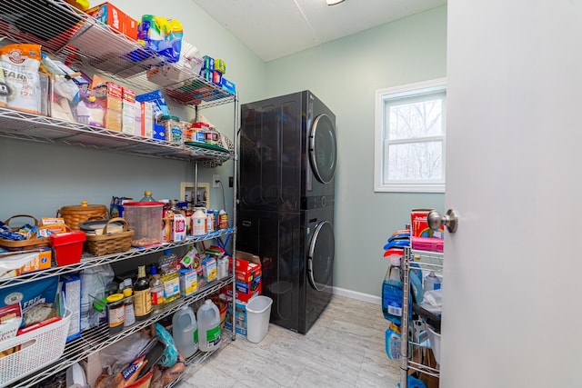 pantry featuring stacked washer / dryer