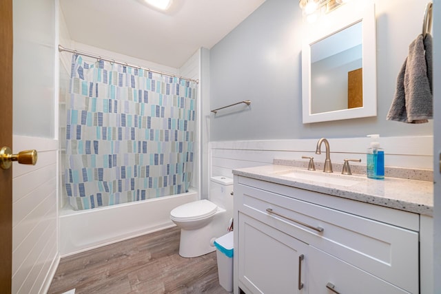 bathroom featuring vanity, toilet, wood finished floors, tile walls, and shower / tub combo