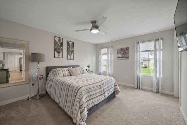 bedroom with ceiling fan, baseboards, and carpet flooring