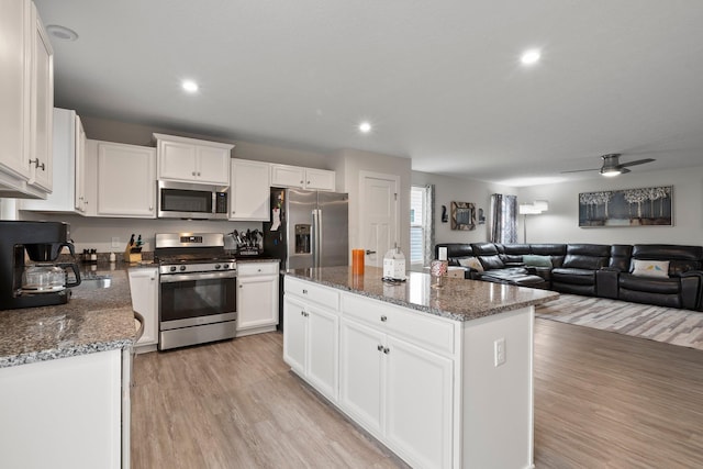 kitchen featuring white cabinets, light wood-style flooring, a center island, and stainless steel appliances