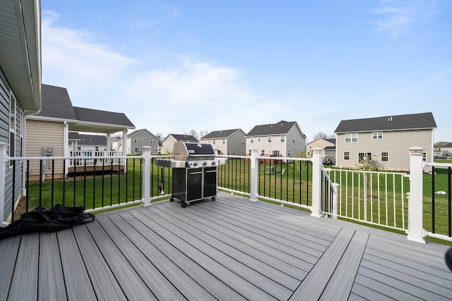 deck featuring a yard, a residential view, and a grill