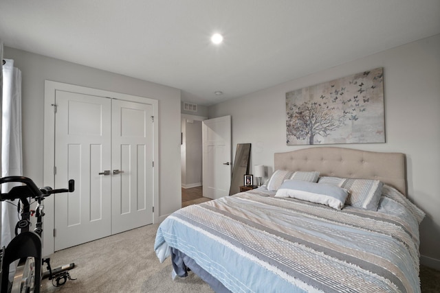 carpeted bedroom with baseboards, visible vents, and a closet