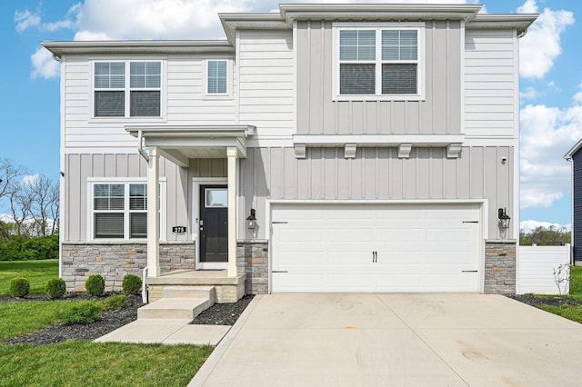 view of front of house featuring board and batten siding, an attached garage, driveway, and stone siding