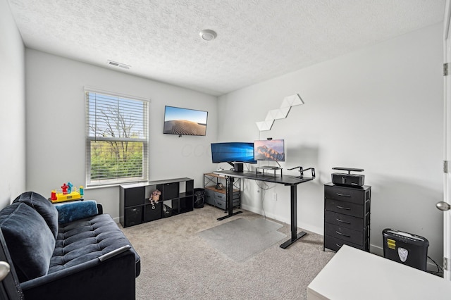 office featuring a textured ceiling, visible vents, and carpet