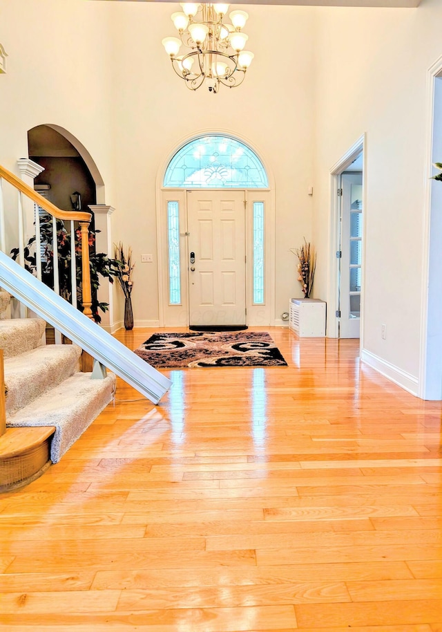 4201 Penrith Ct, Dublin, OH 43016 - entrance foyer with arched walkways, a chandelier, wood finished floors, a high ceiling, and stairway