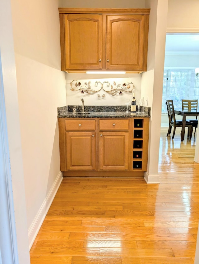 4201 Penrith Ct, Dublin, OH 43016 - bar featuring wet bar, a sink, light wood finished floors, and baseboards