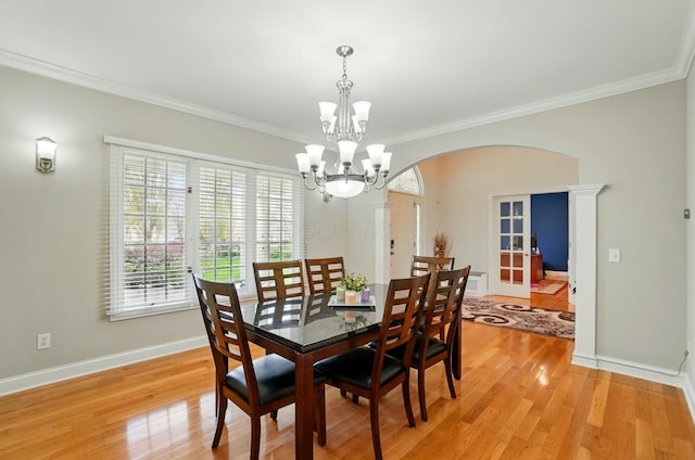 4201 Penrith Ct, Dublin, OH 43016 - dining room featuring crown molding, an inviting chandelier, arched walkways, and a healthy amount of sunlight