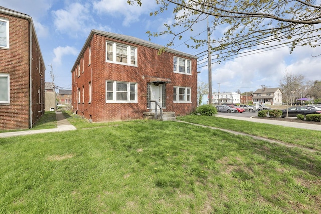 townhome / multi-family property featuring brick siding and a front yard