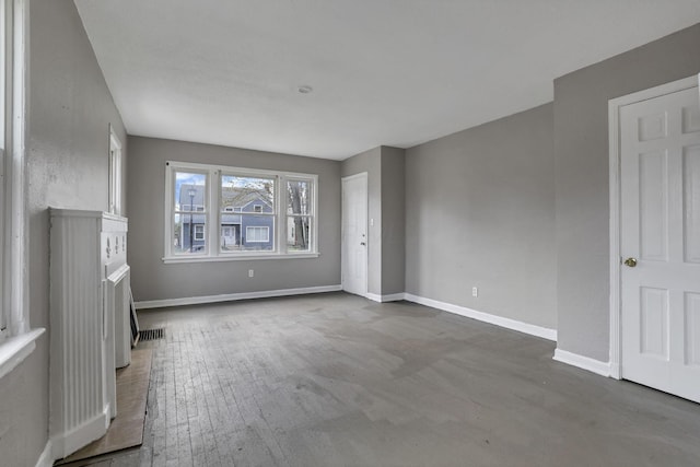 unfurnished living room with baseboards and visible vents