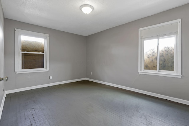 unfurnished room featuring baseboards and dark wood-type flooring