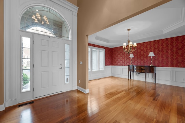 6700 Ballantrae Pl, Dublin, OH 43016 - foyer with an inviting chandelier, visible vents, wood finished floors, wainscoting, and wallpapered walls