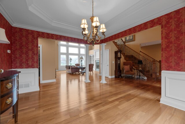 6700 Ballantrae Pl, Dublin, OH 43016 - dining area featuring crown molding, an inviting chandelier, decorative columns, stairway, and a wainscoted wall