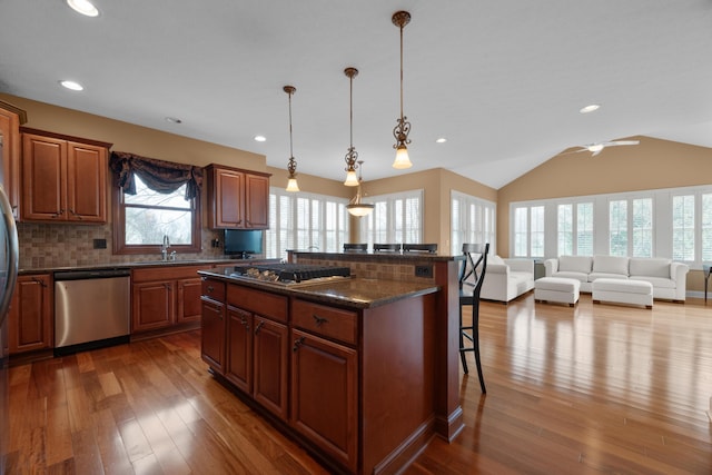6700 Ballantrae Pl, Dublin, OH 43016 - kitchen featuring open floor plan, appliances with stainless steel finishes, wood-type flooring, a kitchen island, and a breakfast bar area