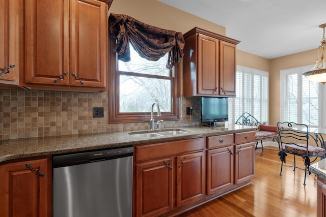 6700 Ballantrae Pl, Dublin, OH 43016 - kitchen with dishwasher, a sink, light wood-style floors, brown cabinets, and stone countertops