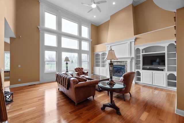 6700 Ballantrae Pl, Dublin, OH 43016 - living room with a ceiling fan, a high end fireplace, light wood-style floors, a high ceiling, and ornamental molding