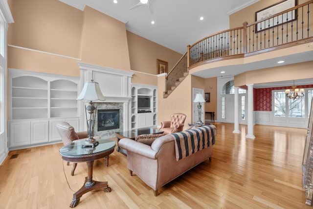 6700 Ballantrae Pl, Dublin, OH 43016 - living area with light wood-type flooring, a premium fireplace, a high ceiling, ornamental molding, and ornate columns