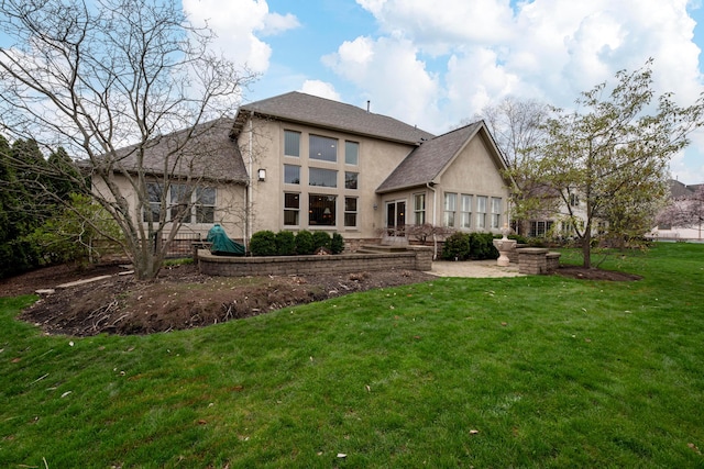 6700 Ballantrae Pl, Dublin, OH 43016 - rear view of house with a lawn, stucco siding, and roof with shingles