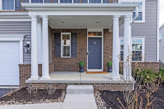 property entrance with covered porch and brick siding