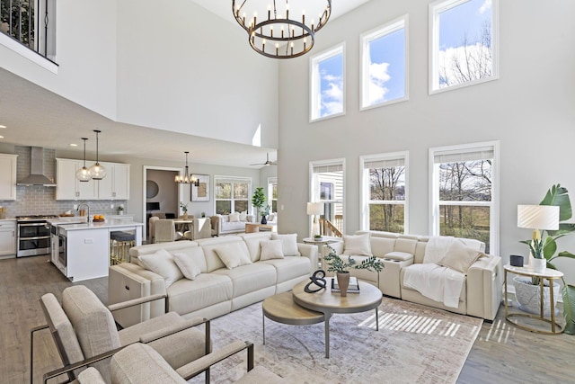 living area with a high ceiling, a notable chandelier, and dark wood-style floors