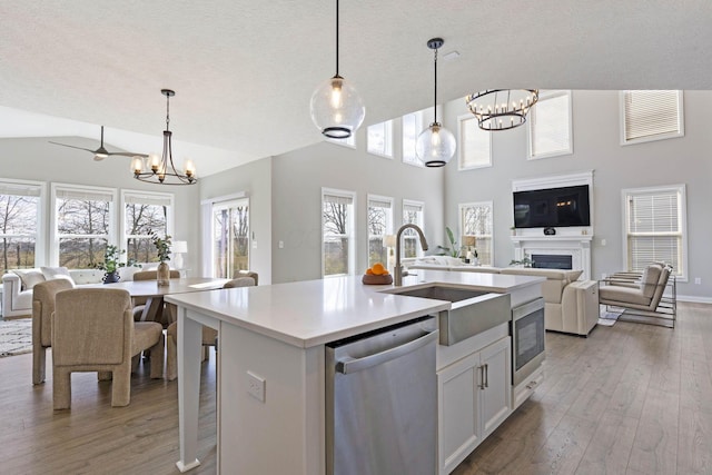 kitchen with light wood-style flooring, a chandelier, a sink, stainless steel appliances, and open floor plan