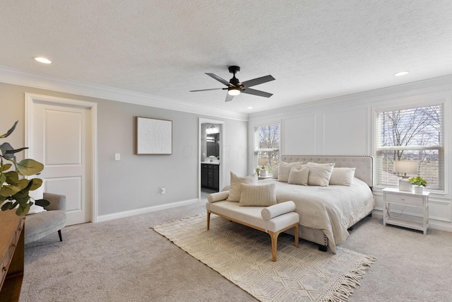 bedroom with a ceiling fan, crown molding, recessed lighting, ensuite bath, and light colored carpet