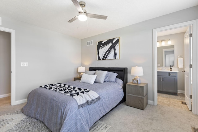 bedroom featuring a sink, visible vents, baseboards, and light colored carpet