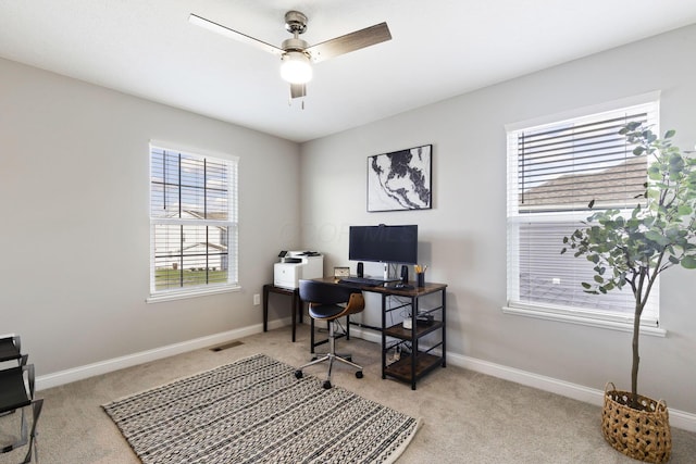 home office featuring a wealth of natural light, visible vents, a ceiling fan, and carpet floors
