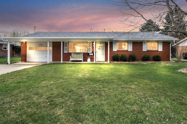 single story home featuring a lawn, a porch, brick siding, an attached garage, and driveway