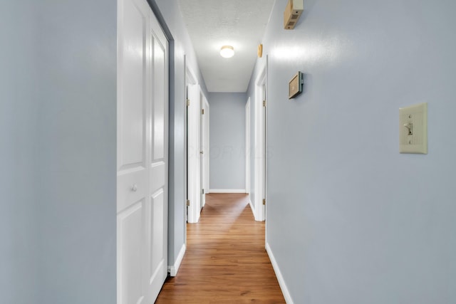 hall with wood finished floors and baseboards