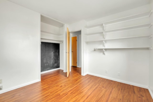 unfurnished living room featuring light wood finished floors and baseboards