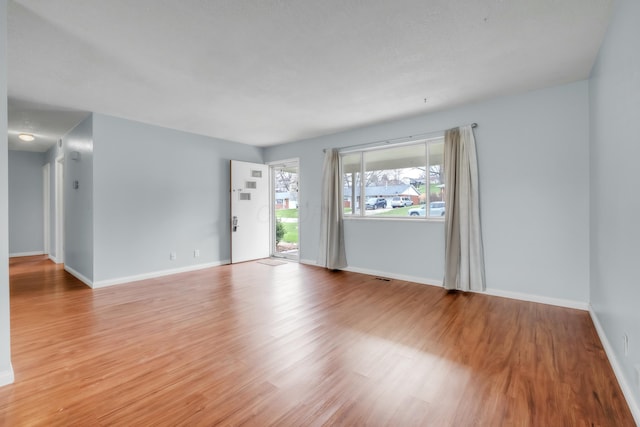 spare room featuring light wood-style flooring and baseboards