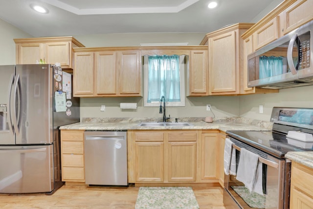 kitchen featuring a sink, light countertops, light brown cabinetry, and stainless steel appliances