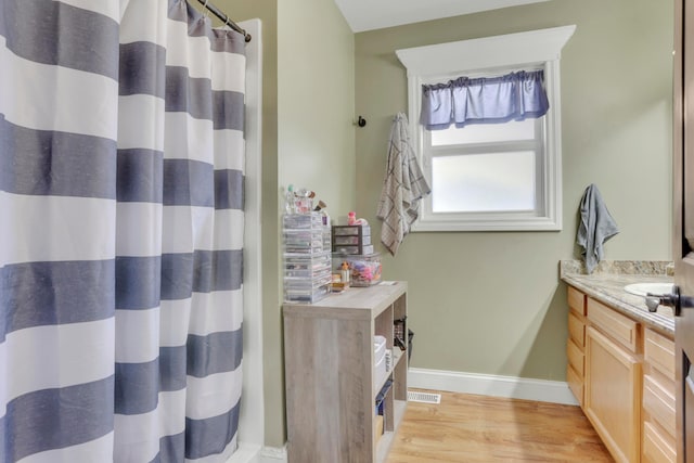 full bath featuring visible vents, baseboards, a shower with shower curtain, vanity, and wood finished floors