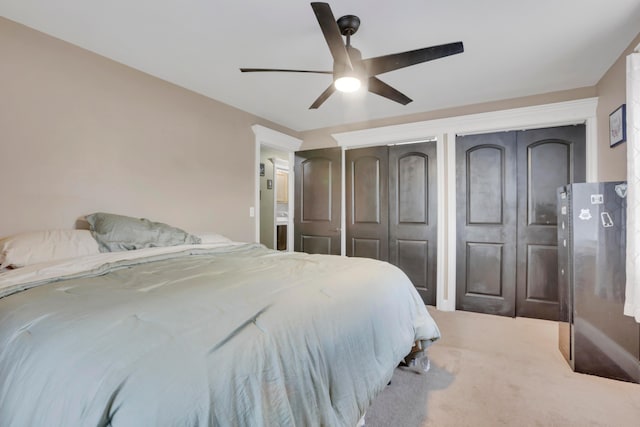 bedroom featuring ceiling fan, multiple closets, and carpet floors