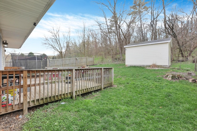 view of yard featuring an outdoor structure, a trampoline, and a shed