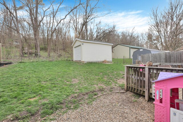 view of yard featuring fence and an outbuilding