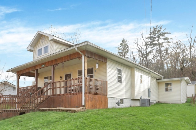 view of front of home with a front yard, cooling unit, and covered porch