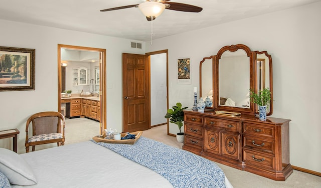 bedroom featuring light carpet, baseboards, visible vents, and connected bathroom