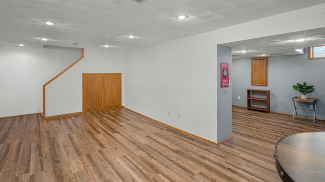 below grade area with recessed lighting, baseboards, and light wood-style flooring