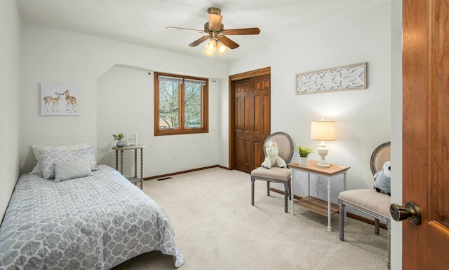bedroom with baseboards, light carpet, ceiling fan, and a closet